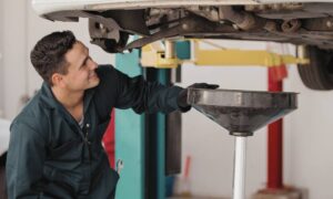 Un garagiste qui fait la vidange d'une voiture