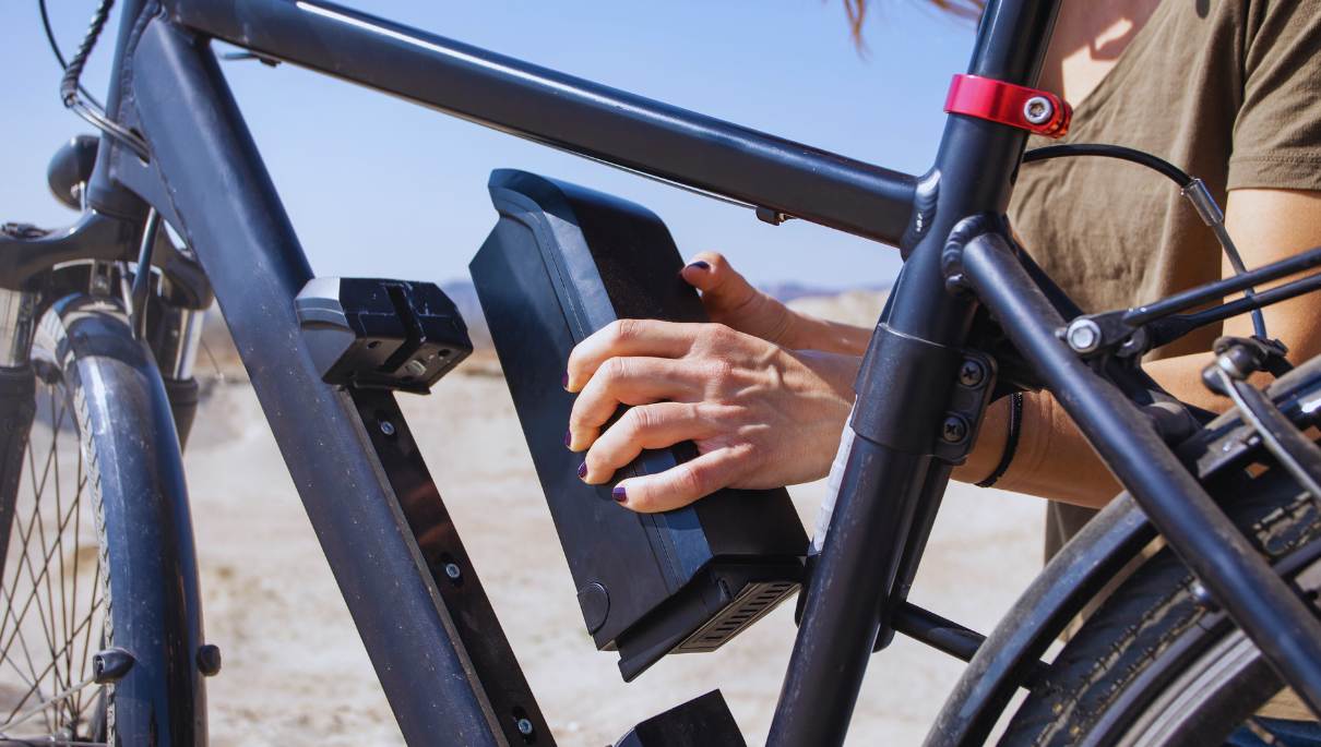 Une personne qui remplace la batterie d'un vélo électrique