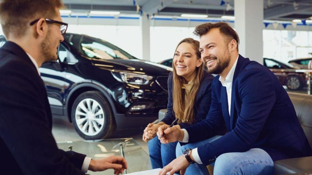 Un couple dans une concession auto avec un vendeur