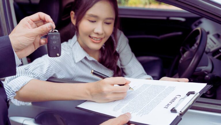 Une femme qui signe un contrat de location de voiture