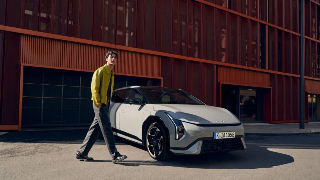 un homme devant une voiture (KIA)